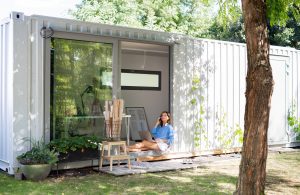 Mature woman working in home office in container house in backyard - Yellowhead storage
